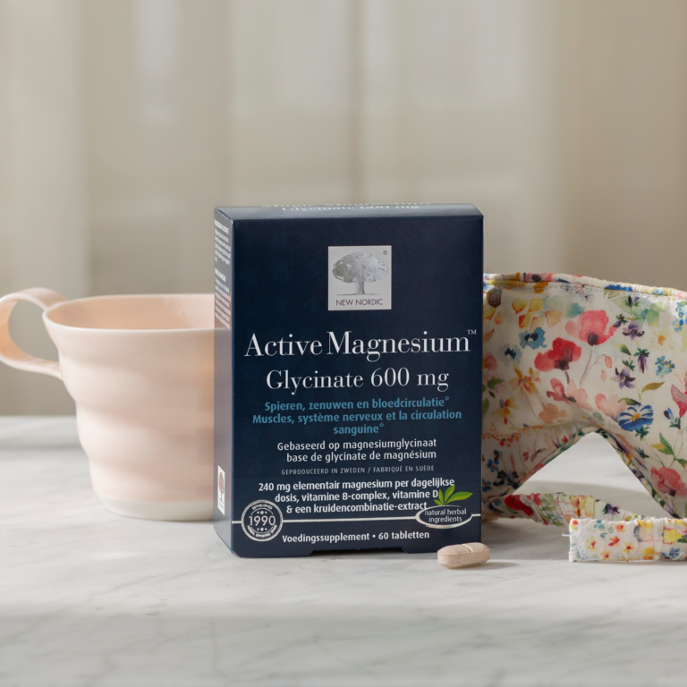 Active Magnesium™ Glycinate 600 mg verpakking naast een mok, slaapmasker en tablet.