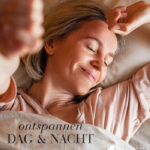 Vrouw glimlacht ontspannen terwijl ze in bed ligt.
