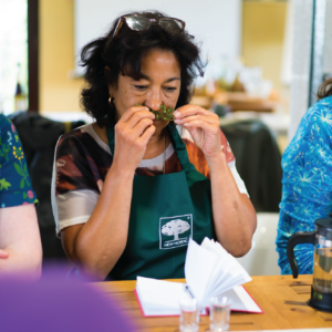 Herbal Schools 37 Vrouw ruikt aan kruiden tijdens een kruiden evenement en verkent planten.