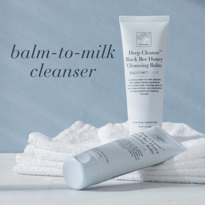Verpakking van Deep Cleanse™ Black Bee Honey Cleansing Balm op een handdoek met de vermelding Balm-to-milk cleanser.