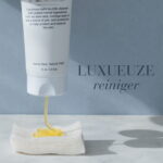 Verpakking van Deep Cleanse™ Black Bee Honey Cleansing Balm met reiniger op een wattenschijfje en de vermelding Luxueuze reiniger.