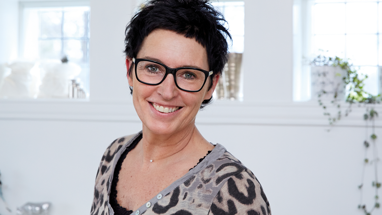 Portret van testimonial Tina, glimlachend in een lichte en natuurlijke setting.