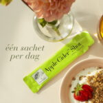 Apple Cider™ Shot sachet naast yoghurt en aardbeien.