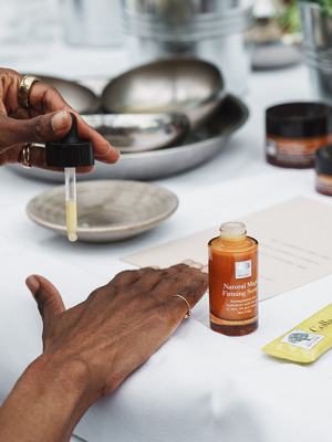 De helende kracht van de natuur – New Nordic-persevenement in Restaurant De kas 3 Persoon brengt Natural Magic™ Firming Serum aan op de hand tijdens een huidverzorgingssessie.